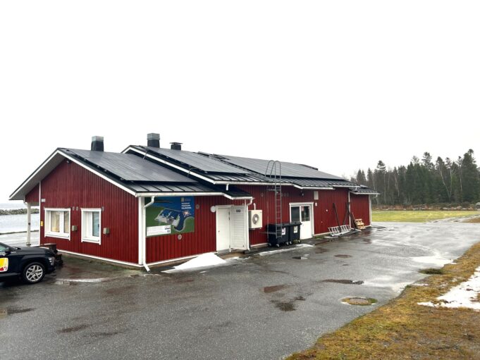 Röd byggnad med solpaneler på taket.